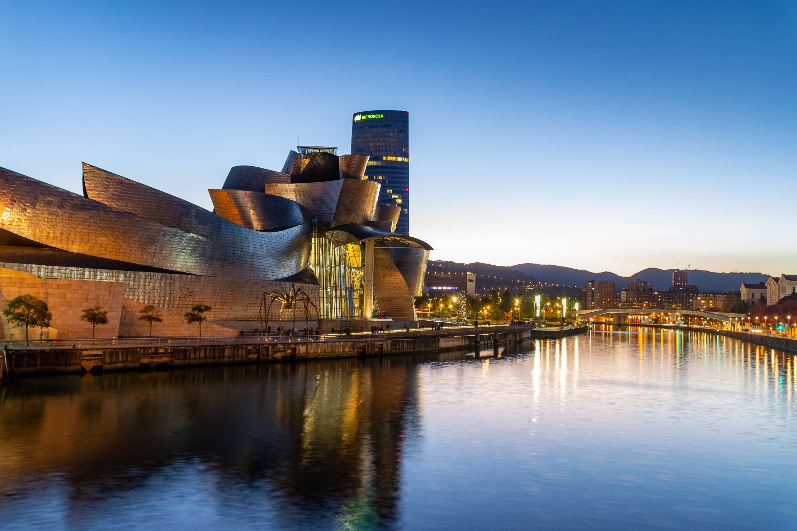 El Guggenheim y los reflejos de Bilbao sobre la ría al caer la tarde